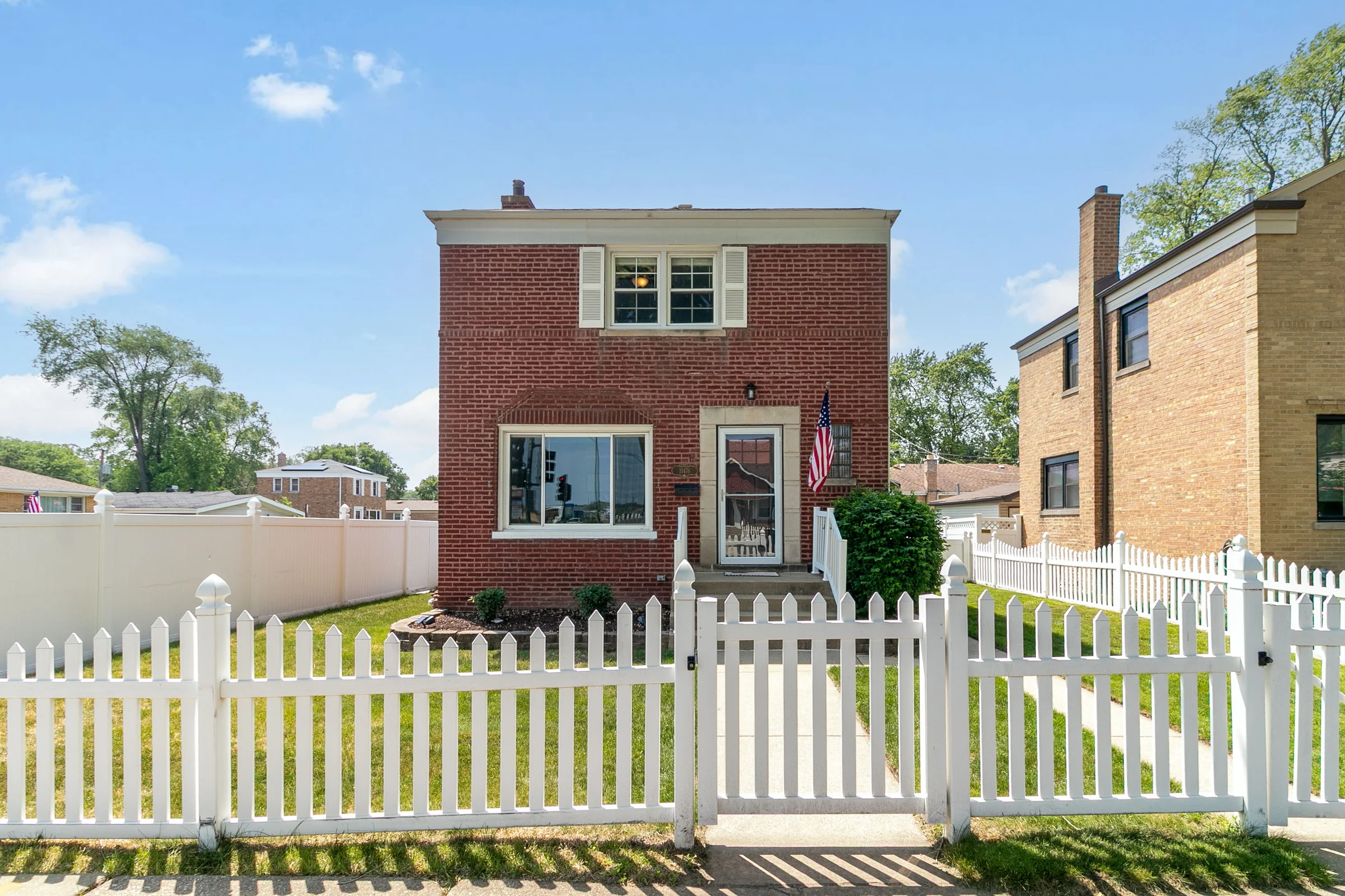 Brick home with a white picket fence