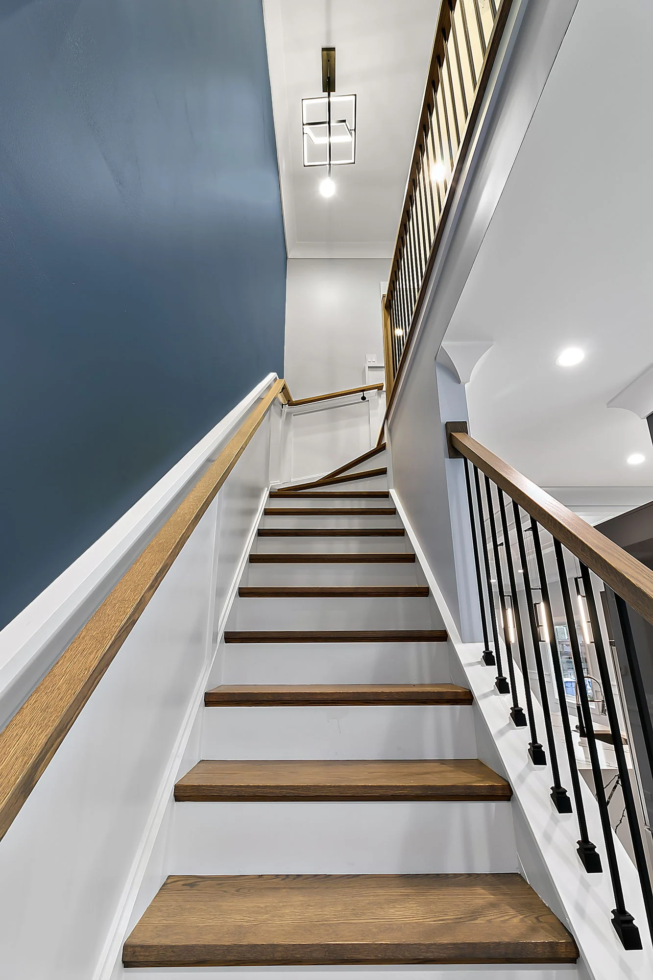 Staircase with dark blue walls and white trim